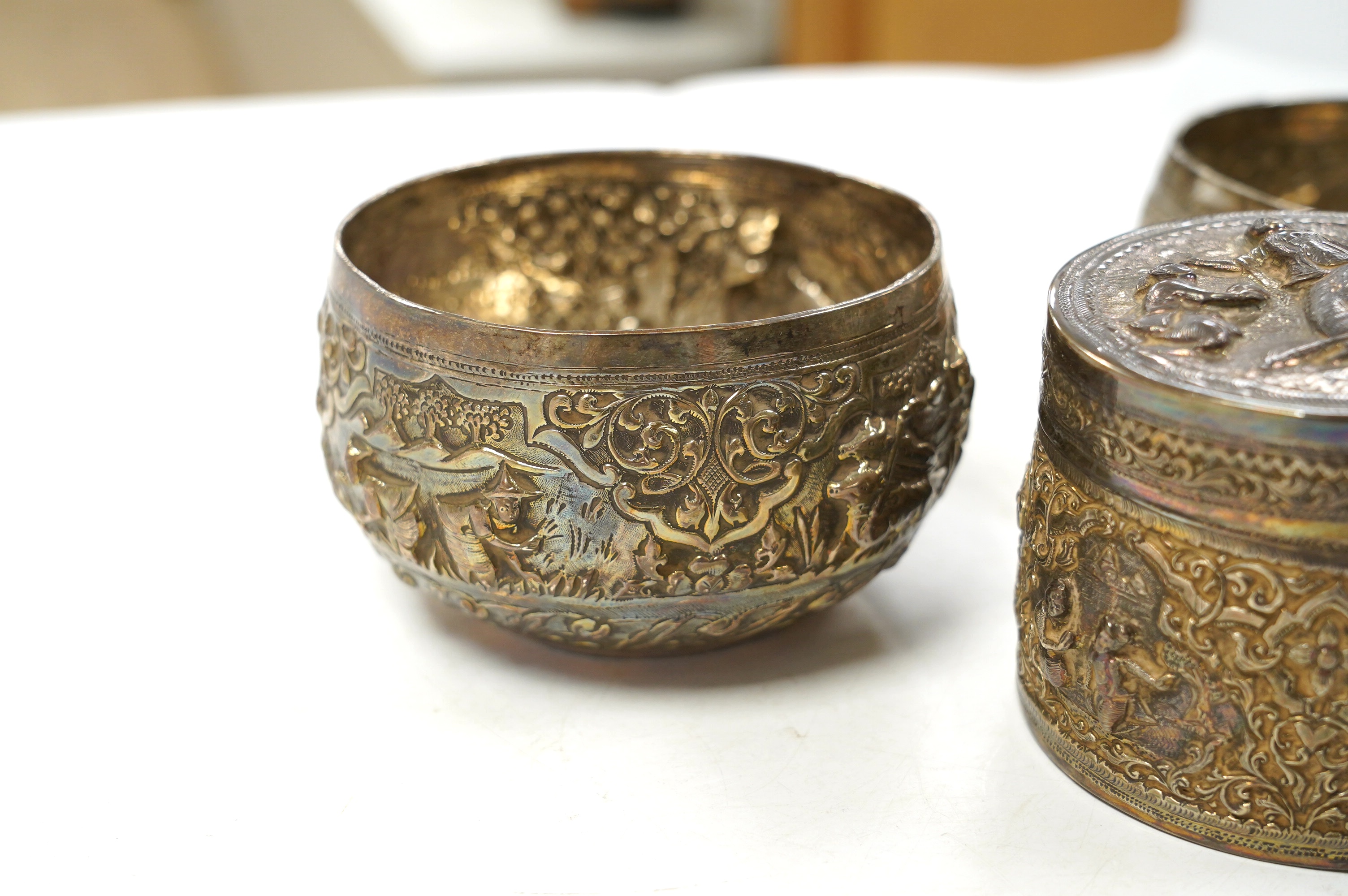 A pair of mid 20th century Indian embossed white metal small bowls, inscribed ' Agri-Horticultural Society Flower Show February 1953', diameter 10.4cm, together with a similar box and cover. Condition - poor to fair